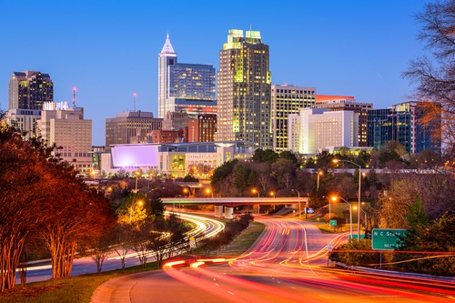 Downtown Raleigh, North Carolina skyline at twilight with light trails along the street below