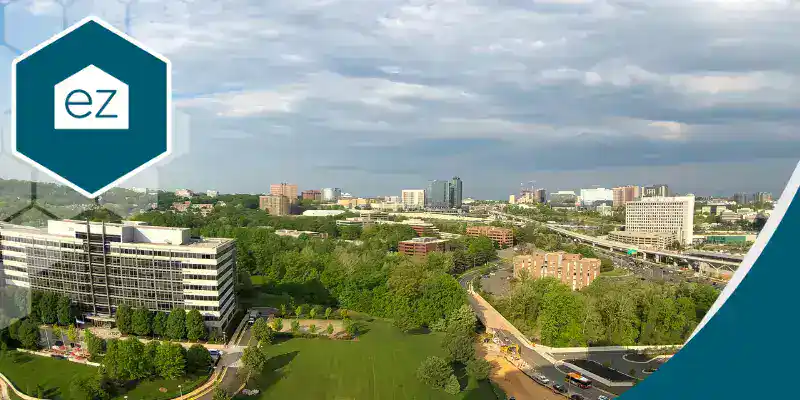 Aerial view of a cityscape with office buildings, roads, and green spaces under a partly cloudy sky—a vibrant landscape ideal for Real Estate Agents seeking Virginia Real Estate Leads. The “ez” logo appears in the top left corner.