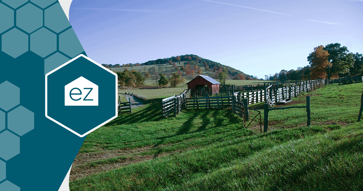 A red barn behind wooden fencing with autumn trees in West Virginia