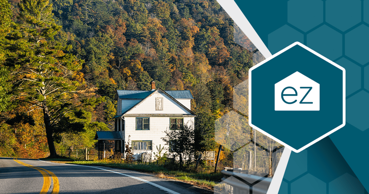 A white farmhouse beside a winding rural road in West Virginia in fall