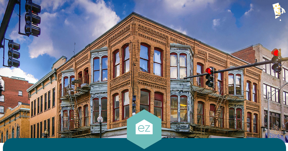 Three-story historic brick building with ornate metalwork and fire escapes on a Providence, Rhode Island street corner