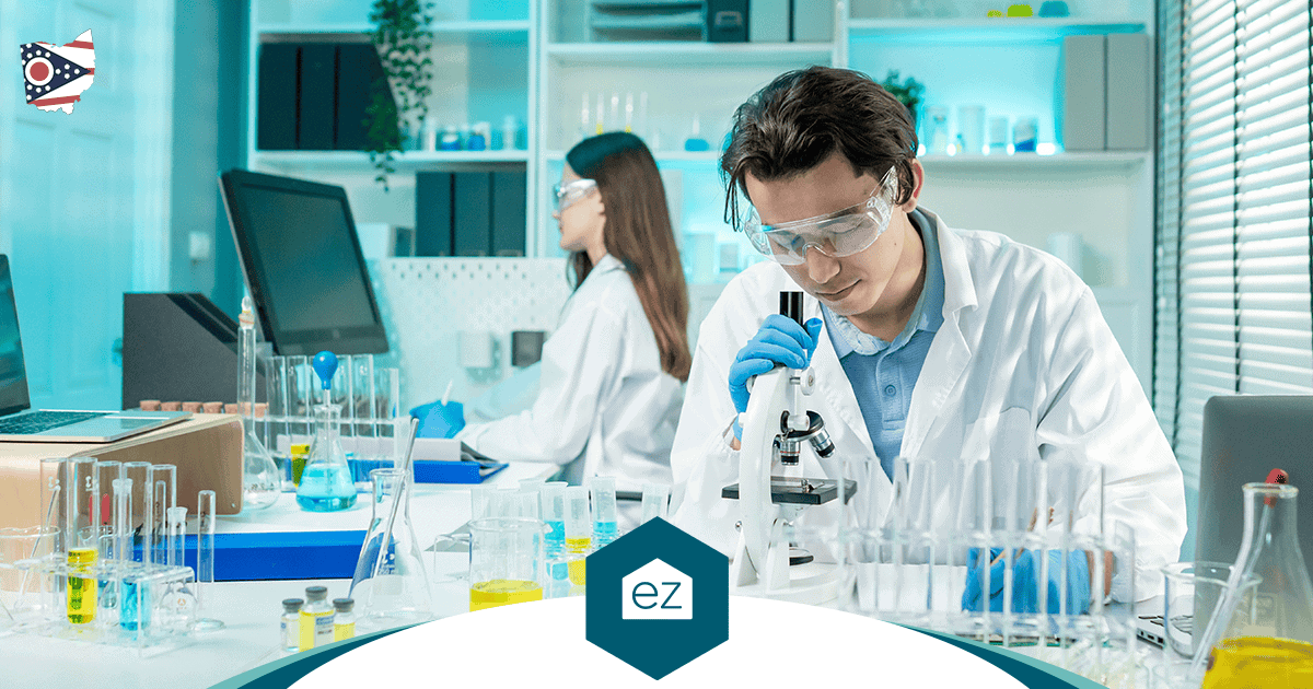Two scientists working with a microscope in an Ohio research laboratory