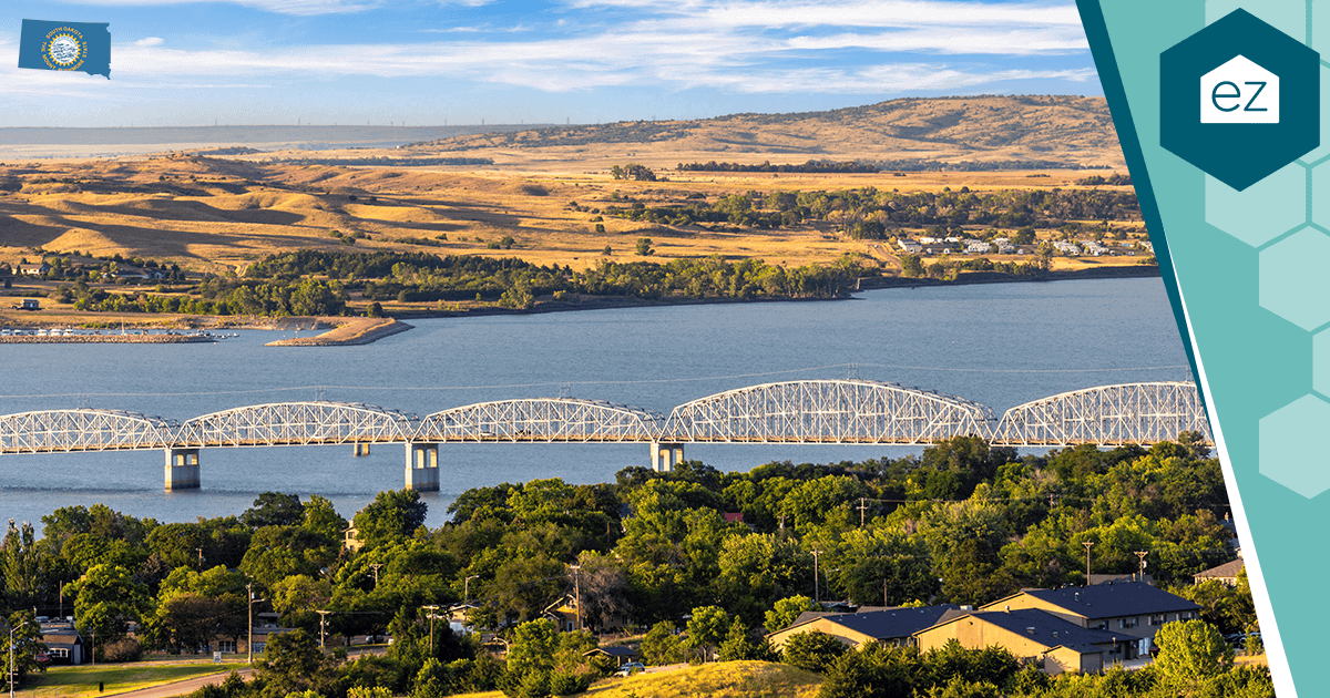 Metal truss bridge spanning the Missouri River in South Dakota with rolling hills beyond