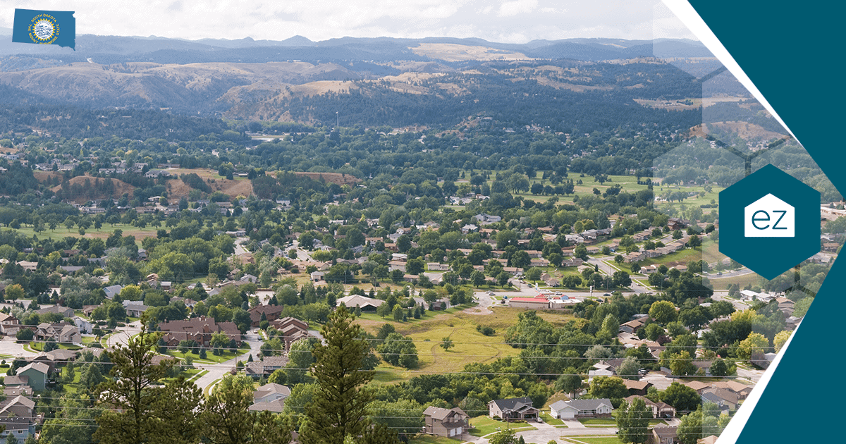 Aerial view of a South Dakota suburban neighborhood with houses, streets, and mature trees against rolling hills