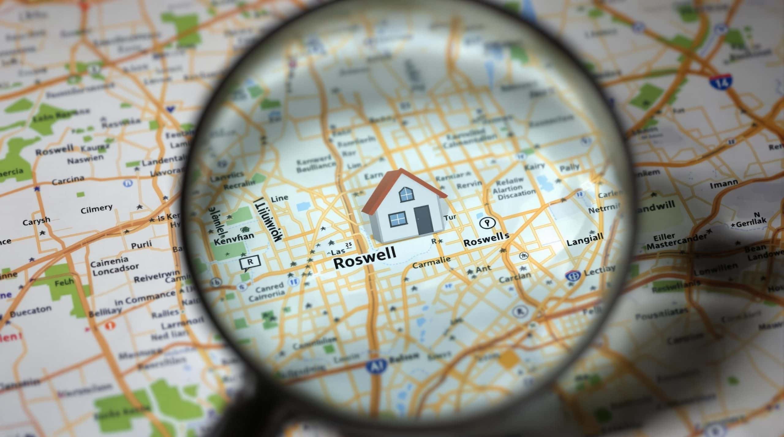 Map with magnifying glass over a house.