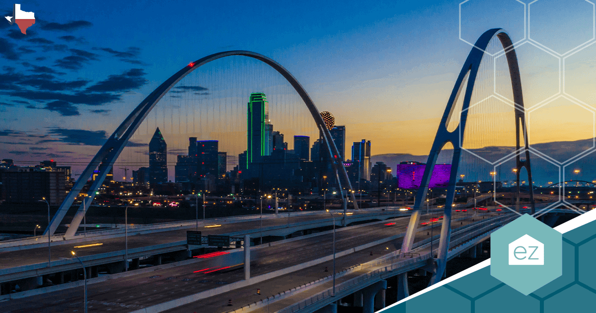 The Dallas, Texas skyline lit at dusk with a bridge in the foreground.