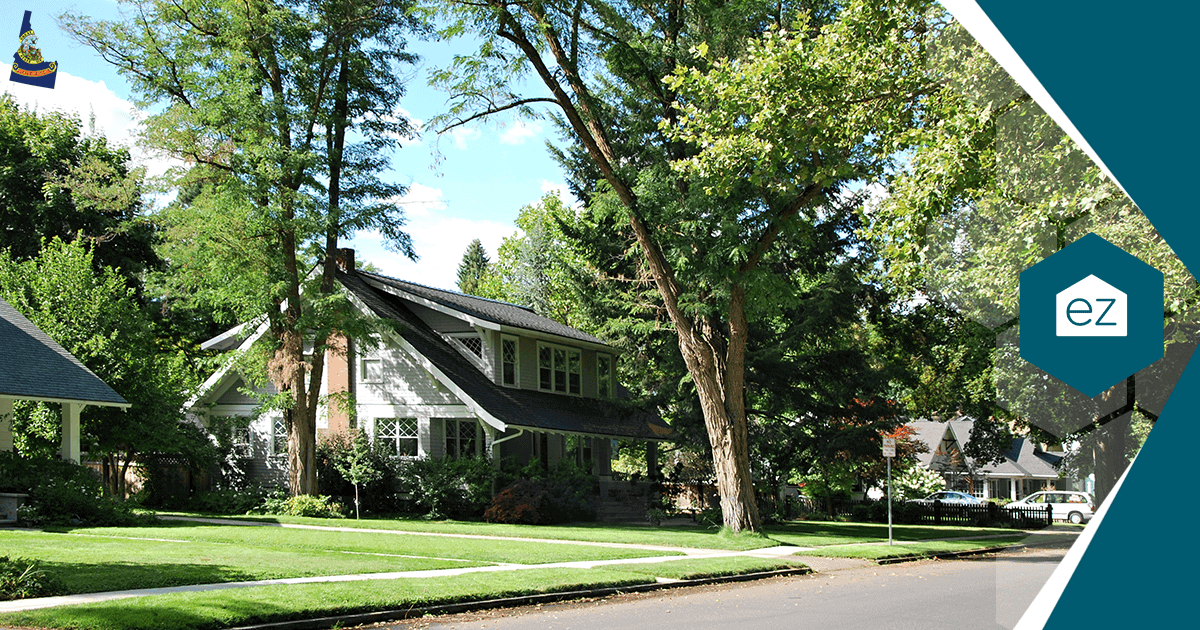 A residential Idaho neighborhood of single-family homes with green lawns and mature trees under a clear sky