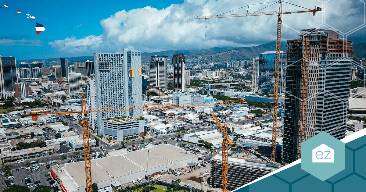 Aerial view of the Honolulu skyline with high-rise buildings under construction and mountains beyond