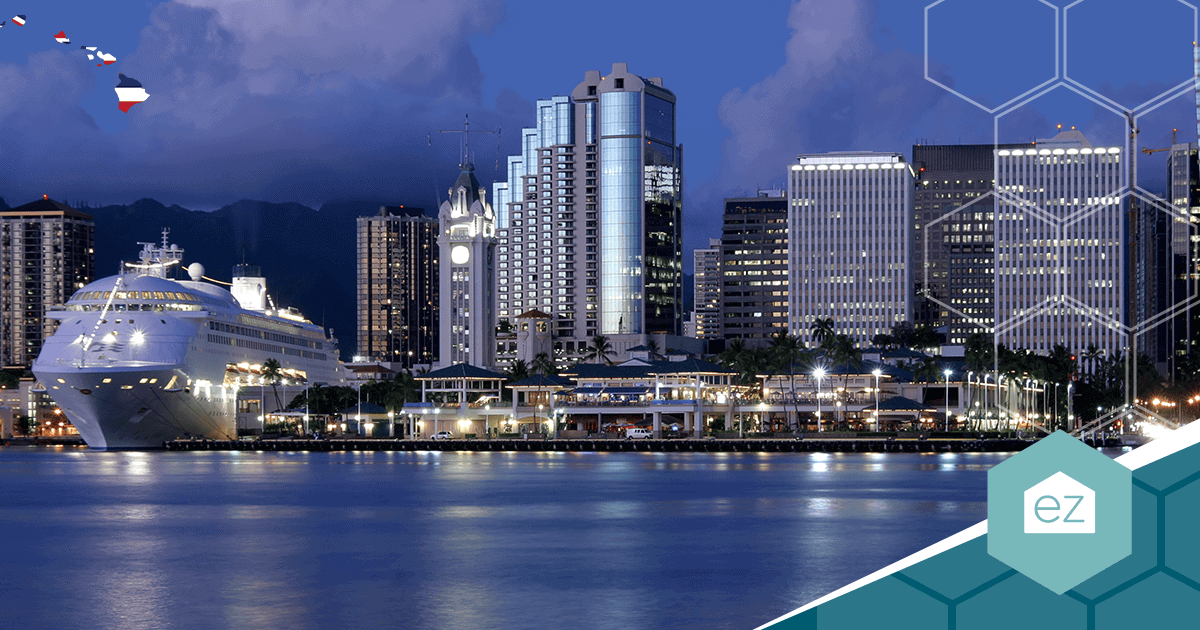 A cruise ship docked beside the Honolulu waterfront and skyline at dusk