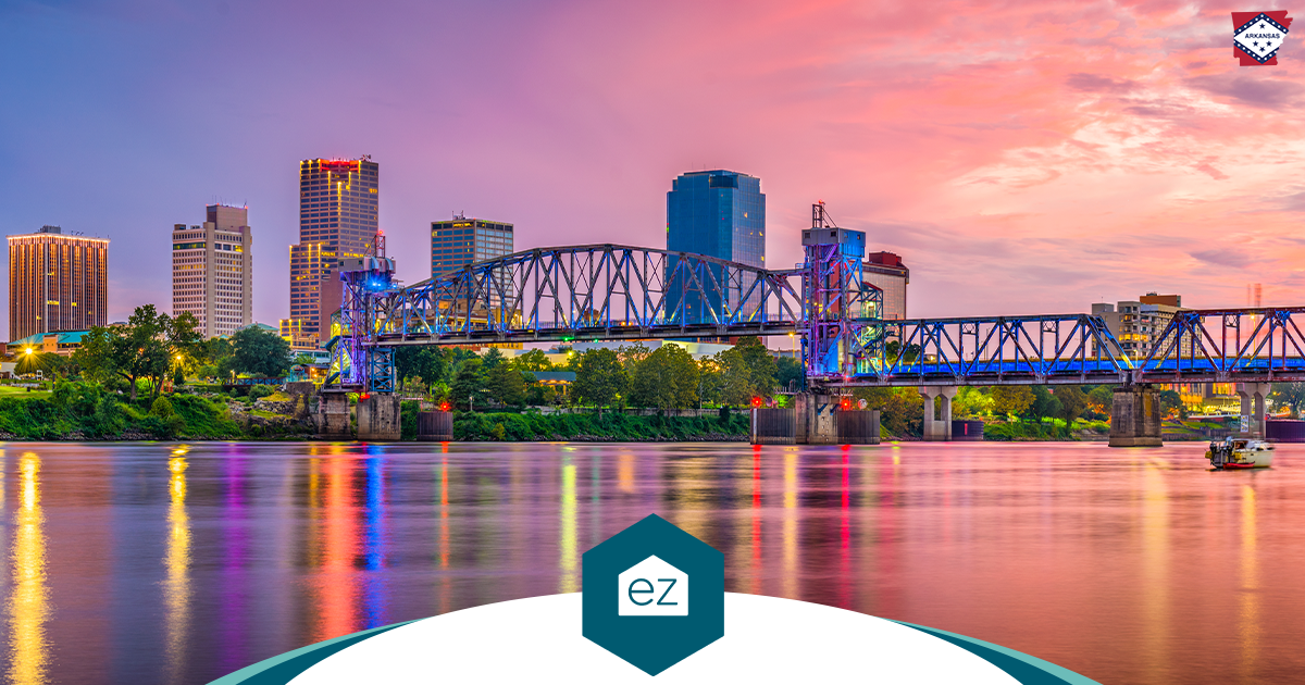 Downtown Little Rock, Arkansas skyline at dusk with the Arkansas River and a steel bridge in the foreground