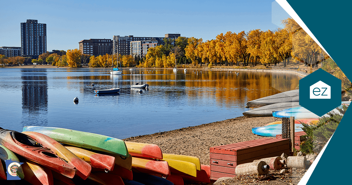 Canoes and rowboats on the shore of Lake of the Isles in Minneapolis with autumn trees