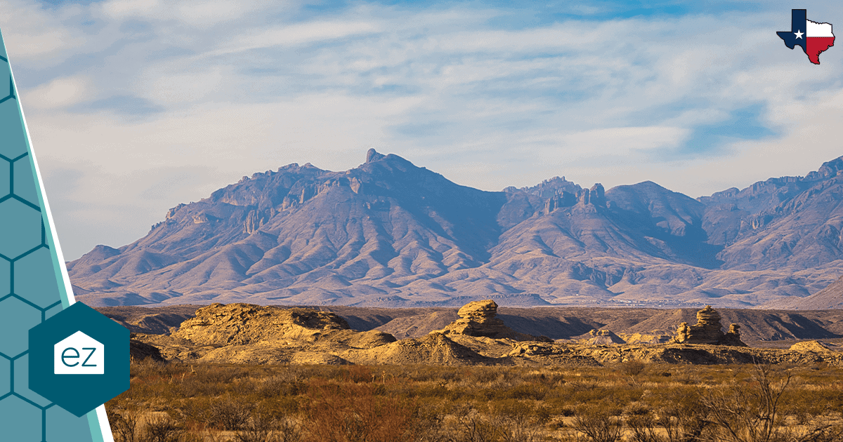 A West Texas desert landscape with rugged mountains under a partly cloudy sky.
