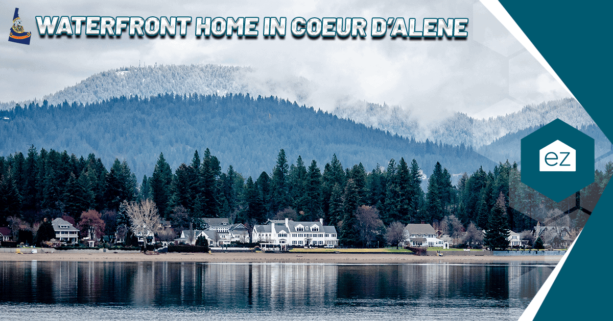 Waterfront homes along the lake edge in Coeur d Alene, Idaho, backed by pine-covered hills and snow-dusted mountains