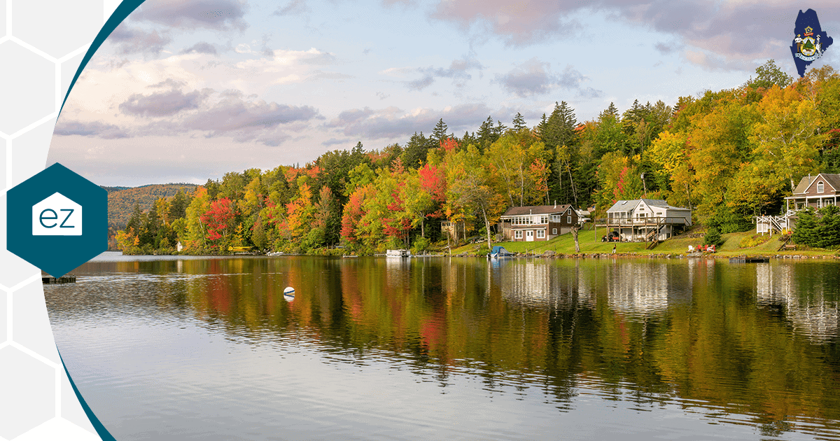 Autumn foliage and lakeside homes reflected in a calm Maine lake
