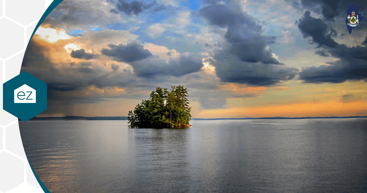 A wooded island in the middle of Sebago Lake in Maine at sunset
