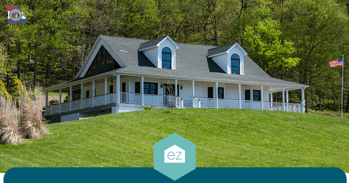 Two-story Missouri home with a wraparound porch on a grassy lot