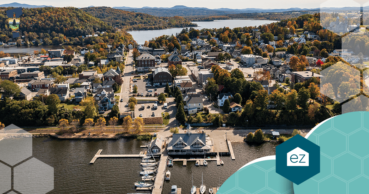 Aerial view of Newport, Vermont, showing tree-lined streets, a marina with boats, and buildings beside the lake