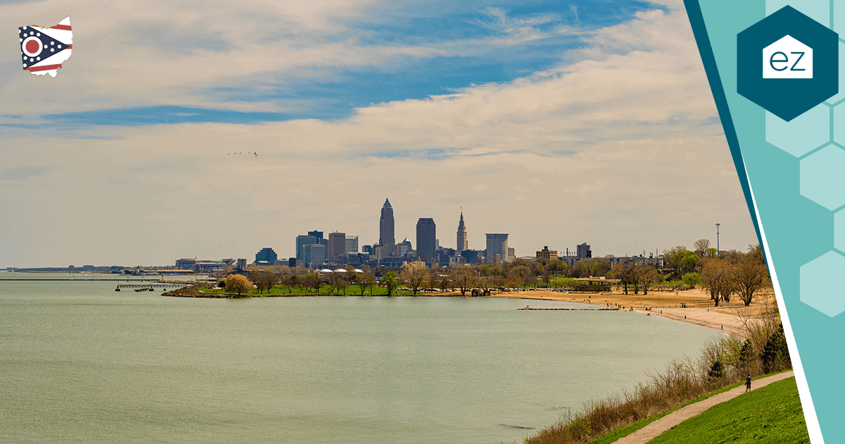 Cleveland skyline along the Lake Erie shoreline under a partly cloudy sky