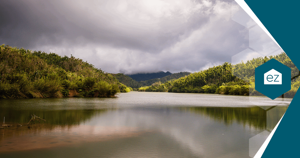 A reservoir winding between forested hills in Puerto Rico's central mountain municipios