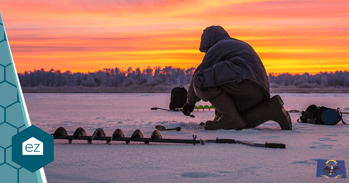 An ice fisher drilling holes on a frozen North Dakota lake at sunrise