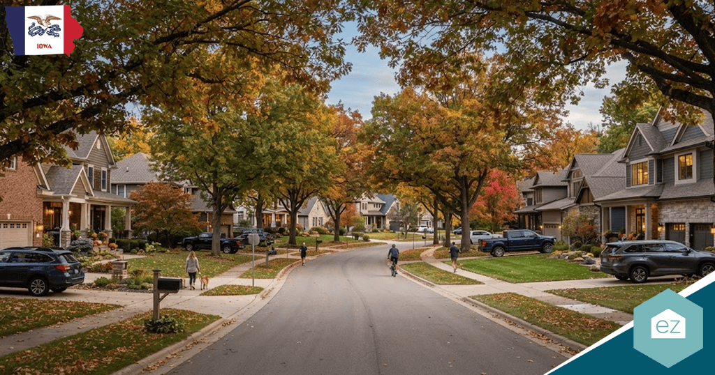 Curved suburban street lined with houses and autumn trees. People walk, bike, and cars are parked along the road—an inviting scene ideal for generating Iowa real estate leads. Logos are visible in the top left and bottom right corners.