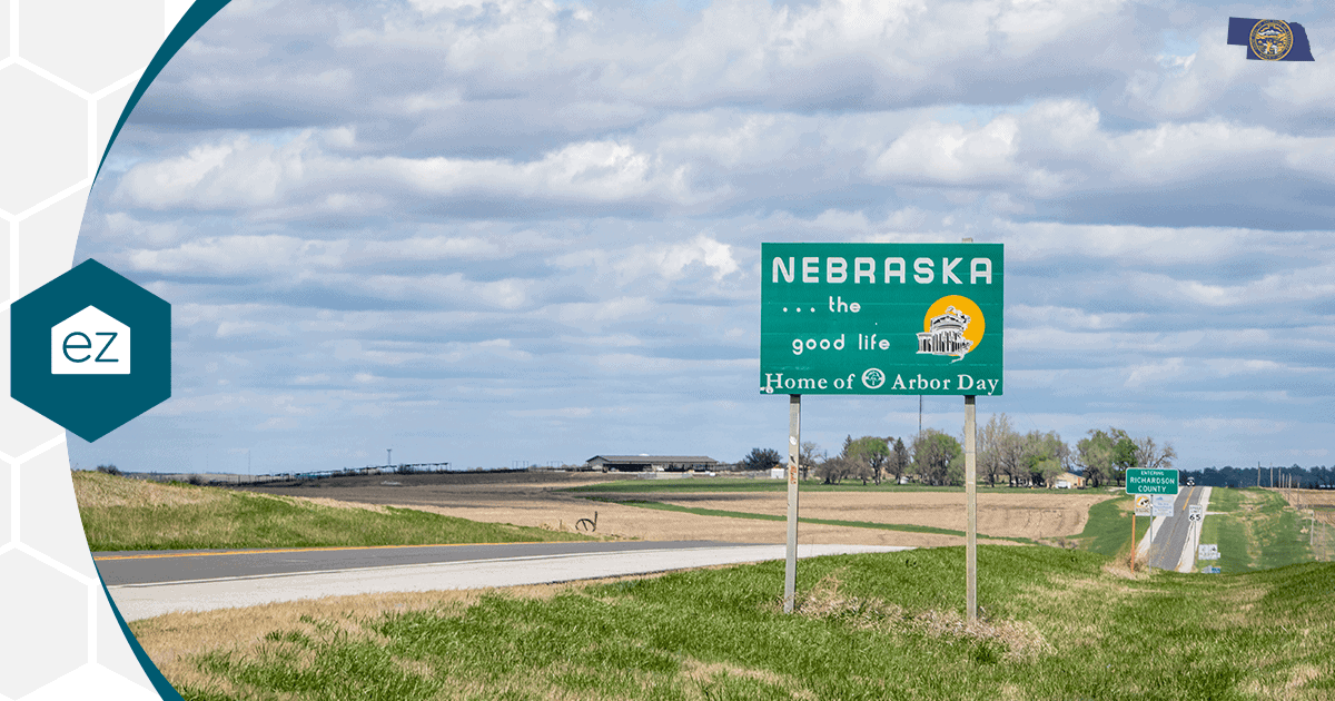 Nebraska state welcome sign along a rural highway lined with farm fields