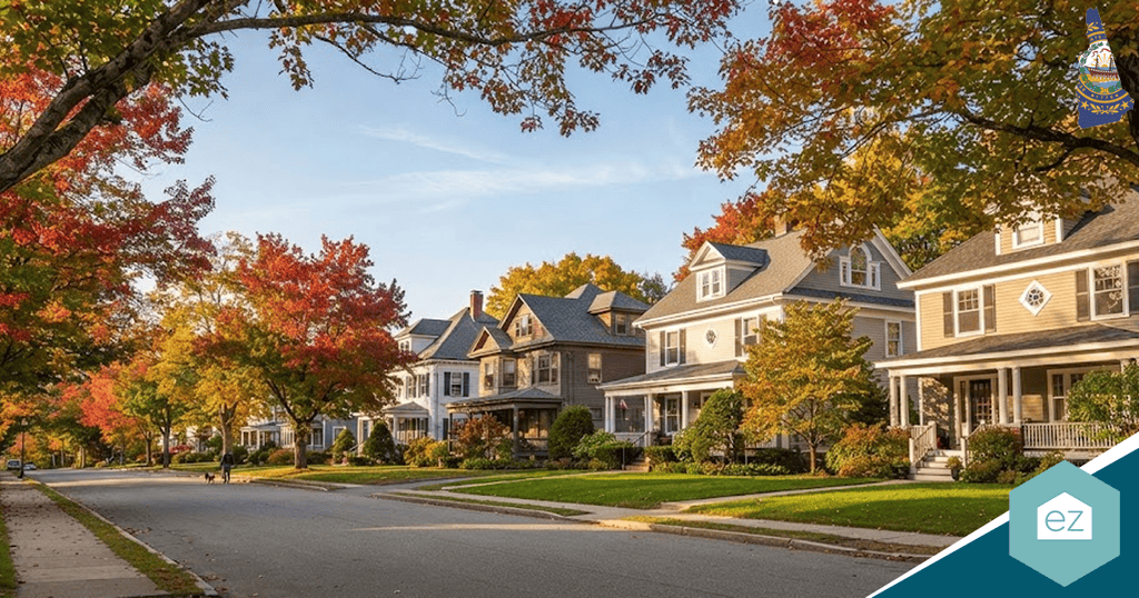Tree-lined suburban street with detached houses, manicured lawns, and autumn foliage under a clear sky—the perfect setting for attracting New Hampshire real estate leads.