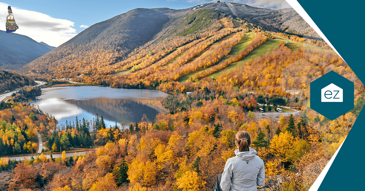 Person overlooking a New Hampshire lake and mountains with autumn foliage