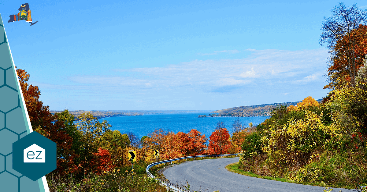 A winding road through autumn foliage toward a Finger Lakes lake in New York