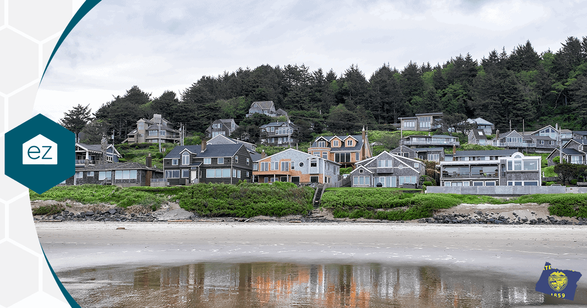 Oregon Coast homes set on a grassy hillside above a wide sandy beach