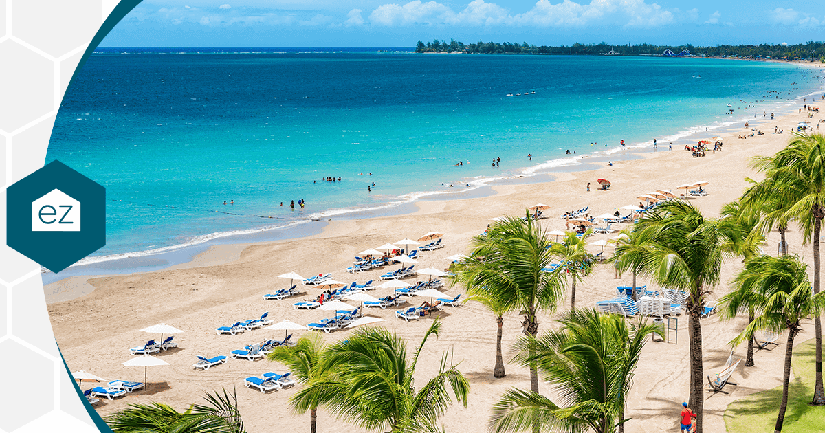 A wide sandy beach with swimmers and sun loungers in San Juan, Puerto Rico