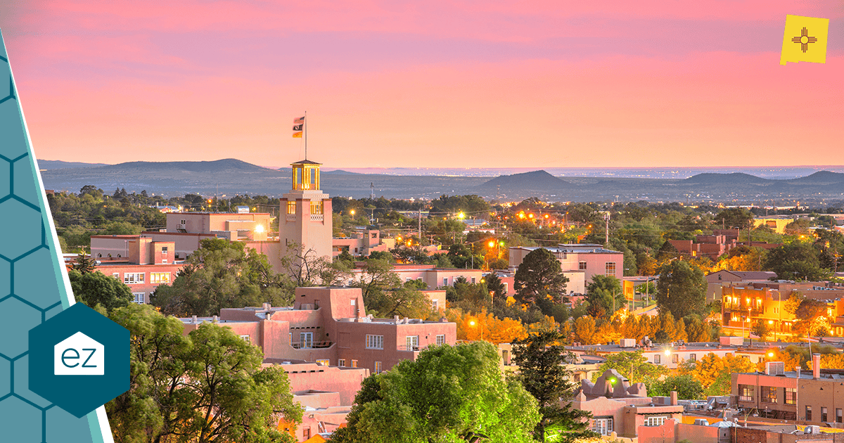 Santa Fe, New Mexico skyline at sunset with adobe-style buildings and mountains
