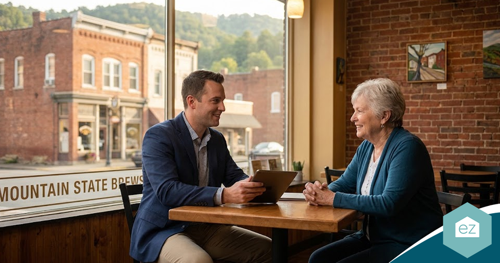 A man in a blazer and an older woman sit at a cafe table, reviewing West Virginia real estate leads on a tablet together.