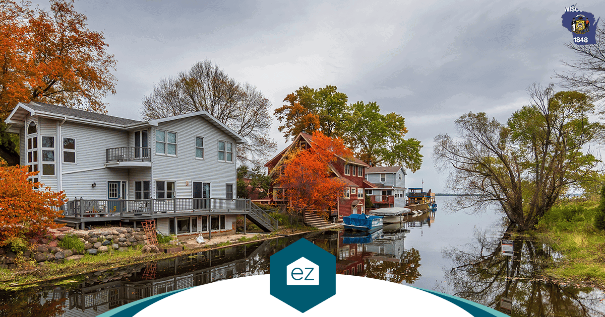 Waterfront homes and boat docks along a Wisconsin lake shore lined with autumn trees, the second-home market behind the North region's growth
